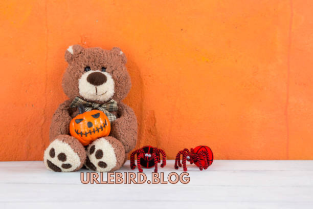 A realistic stuffed animal spider on a cozy blanket.