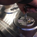 "Cleaning the shaft seal of an Ankarsrum stand mixer with a soft-bristled brush."